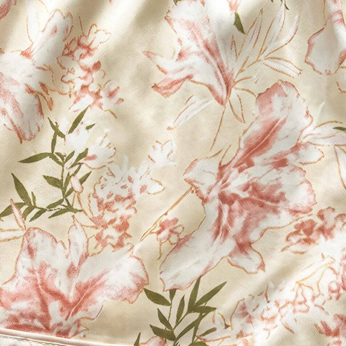 Floral women’s night suit fabric close-up with pink flowers on beige background