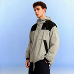 Venzina Sunscreen Jacket for Men worn, 3/4 side view, grey-black color-block hoodie with drawcord hem, studio blue backdrop