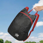 Venzina black and red lightweight backpack held against a blue sky