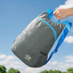Venzina lightweight foldable backpack in grey being carried by hand, waterproof travel daypack
