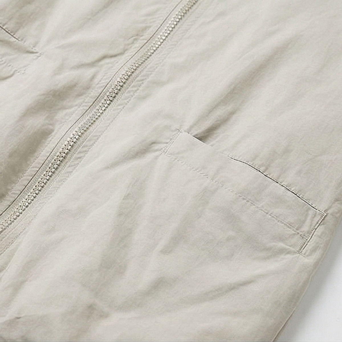 Venzina sun protection jacket women close-up pocket detail, beige fabric showing front zipper alignment and clean stitching on lightweight material