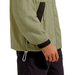 Venzina sunscreen jacket detail, side hem drawcord toggle and black cuff on olive fabric, white background