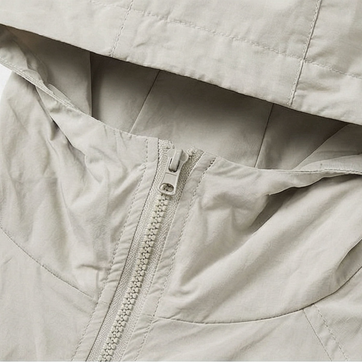 Venzina women's sun protection jacket close-up detail, beige fabric showing front zipper, hood seam stitching, and smooth lightweight texture