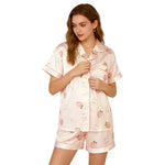 Woman wearing a pink pajama set with animal prints on a white background