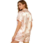 Women’s pink satin night suit with peach print, back view on white background