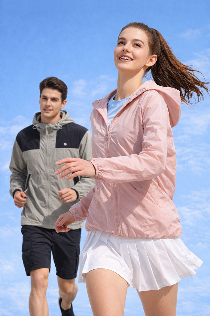 Woman in pink UPF 50+ sun protection hooded jacket running outdoors - UV blocking activewea
