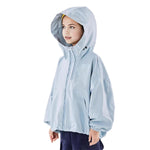 Girl wearing a light blue hooded kids outdoor jacket, side view — breathable windbreaker jacket with high collar design on white background.
