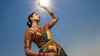  Indian woman in traditional saree raising hand toward bright sun — UV protection tips for India