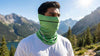 Man wearing a green balaclava face mask outdoors in the mountains