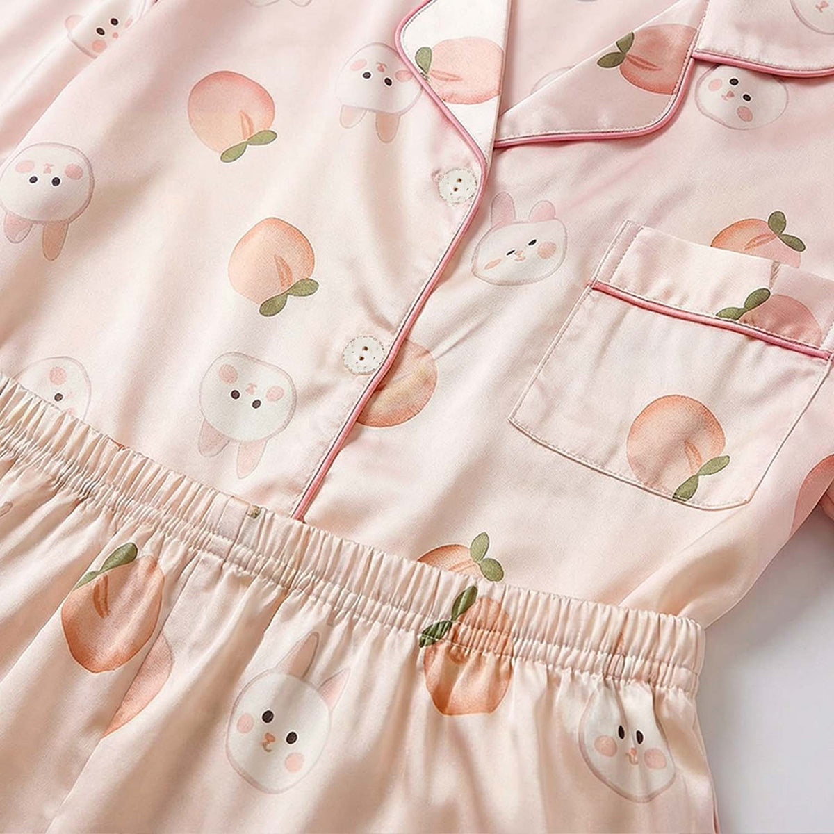 Pink pajama set with cartoon peach and sheep design on a light pink background
