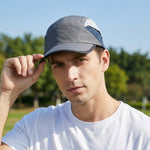 Venzina Lightweight Cap worn by man outdoors adjusting brim with gray breathable panel design