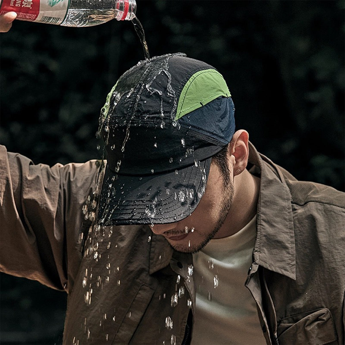 Venzina Quick Dry Cap worn outdoors with water poured over the fabric showing water-repellent surface