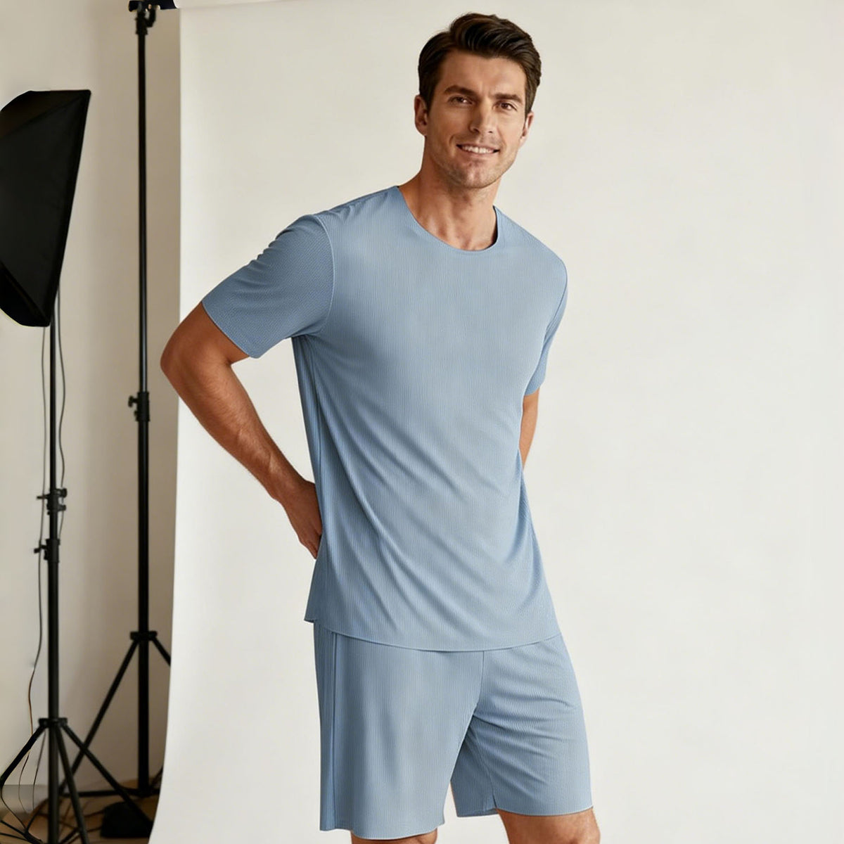 Venzina mens pyjamas worn by male model, light blue ribbed short sleeve top and shorts, front view in studio setting