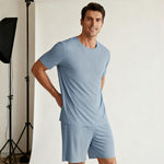Venzina mens pyjamas worn by male model, light blue ribbed short sleeve top and shorts, front view in studio setting