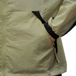 Venzina sun protection jacket close-up, olive fabric texture with zip pocket and black cuff, white background
