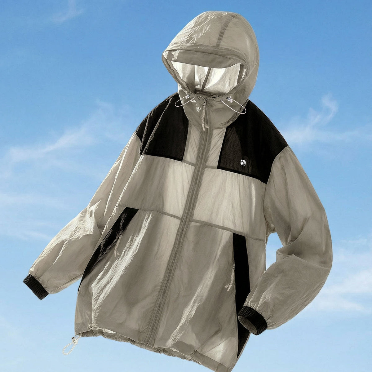 Venzina sun protection jacket laid flat, grey-black color-block with visor hood and drawcords, outdoor blue sky background