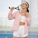 Venzina sun protective jacket in pink, tennis court side view with racket on shoulder, reflective piping visible