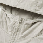 Venzina women's sun protection jacket close-up detail, beige fabric showing front zipper, hood seam stitching, and smooth lightweight texture