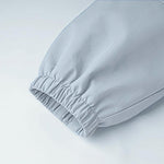 Close-up of light blue kids outdoor jacket sleeve — elastic cuff detail showing windproof design and breathable windbreaker fabric.